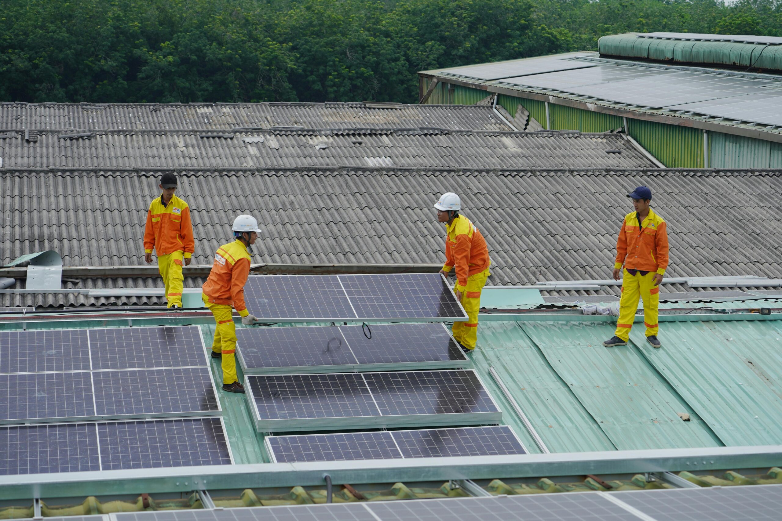 Workers installing solar panels on a roof for sustainable energy solutions.